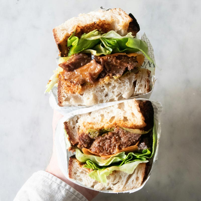 person holding cut sandwich